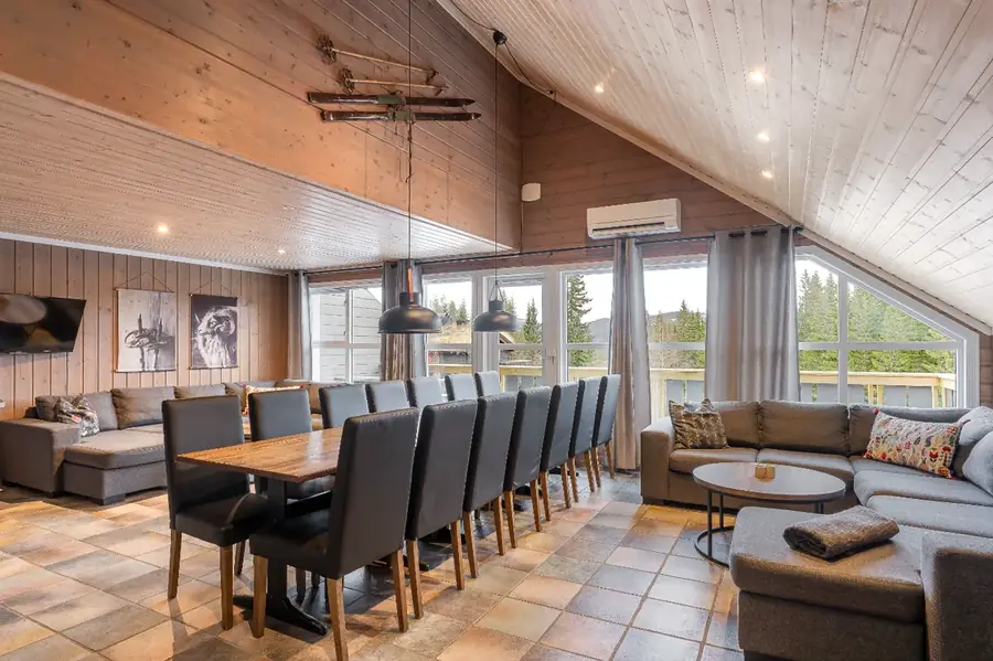 Allrum med matbord för 16 personer och stor soffa i stuga Bakkebygrenda 1B, Trysil